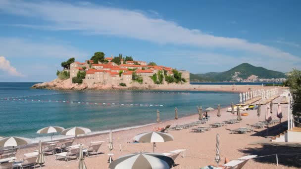 Πολυτελής παραλία με φόντο το νησί Σβέτι Στεφάν στη Μπούντβα, Μαυροβούνιο — Αρχείο Βίντεο