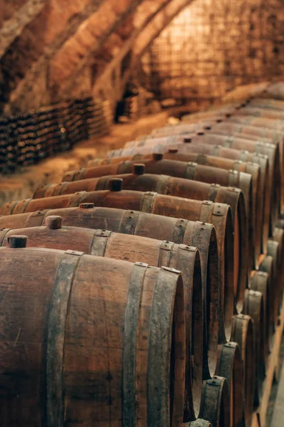 Velhos barris de madeira com vinho nas antigas caves medievais — Fotografia de Stock