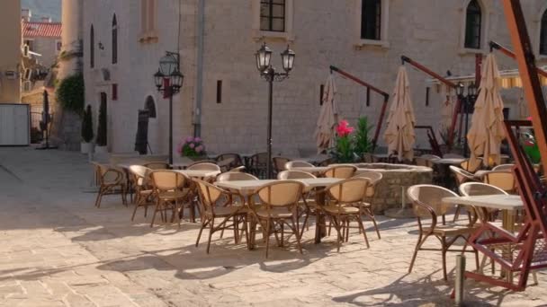 Empty outdoor cafe with tables and chairs in old town of Budva, Montenegro — 图库视频影像