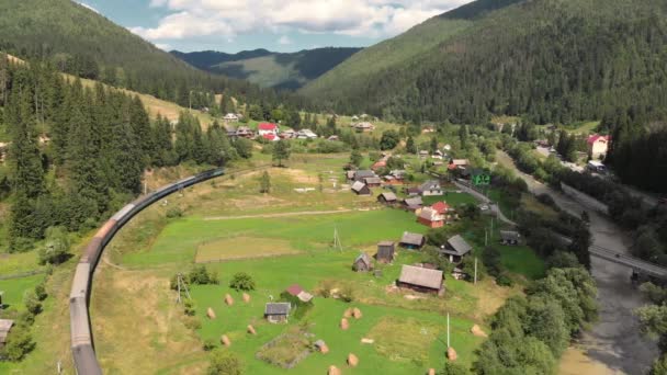 Tembakan udara kereta api yang melewati desa di pegunungan Carpathian di Ukraina — Stok Video