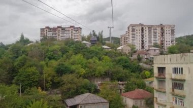 Gürcistan 'daki Chiatura madenci şehrindeki eski Sovyet döneminden kalma binaların önünden geçen kablo TV arabası.