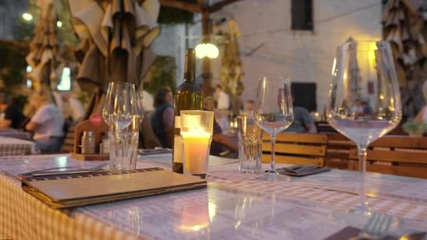 Escena desenfocada de personas cenando en un restaurante al aire libre por la noche — Vídeos de Stock