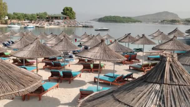 Arnavutluk 'un Ksamil kentinde şemsiyeli ve güneşlikli güzel plaj — Stok video