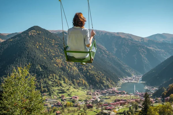 Young woman on a swing with the view of the Uzungol resort town, Turkey — Stock Photo, Image