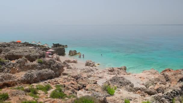 Hermosa playa salvaje vacía con sombrillas y agua de mar hermosa calma — Vídeos de Stock