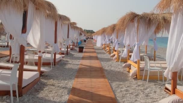 Canopy tengerparti ágy fehér függönyökkel egy üres strandon nyáron — Stock videók