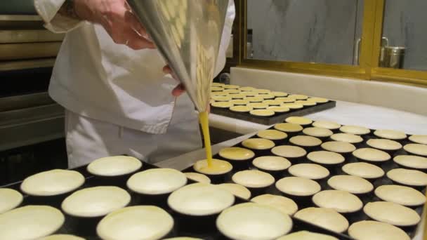 Pasticcere riempie pasticceria tradizionale portoghese pastello de nata con crema pasticcera — Video Stock