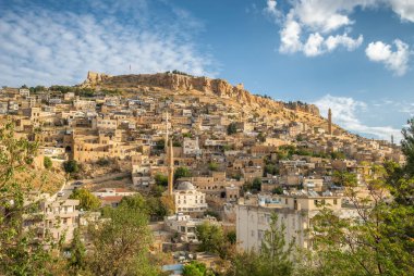 Geleneksel taş evleri olan Mardin eski kasaba manzarası. Türkiye 'nin doğusunda popüler bir turizm merkezi. Güneşli bir günde tarihi yapılar ve Mardin Kalesi.