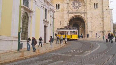 Lizbon, Portekiz - 24 Mart 2022: Lizbon Alfama, Lizbon 'daki Lizbon katedralinden geçen tarihi sarı tramvay. Eski kasabada geleneksel Lisboa tramvayı.
