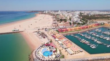 Güney Portekiz 'in Algarve bölgesindeki Praia da Rocha ve Portimao tatil köylerinin hava manzarası. Lüks marinalı İHA görüntüleri, güzel uzun beyaz kumlu plaj ve Portimao şehir manzaralı.