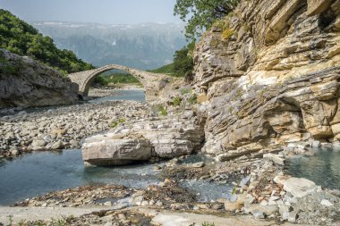 Arnavutluk 'un Permet kentinde Benja Termal Hamamları. Arnavutluk 'ta eski kemer şeklinde taş köprü, nehir ve sıcak suyla dolu havuzlar.