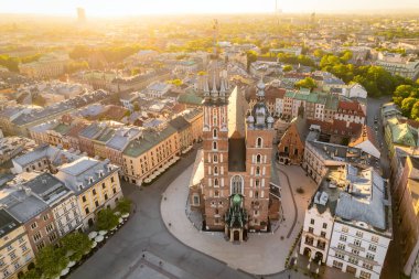 Pazar meydanındaki St. Marys Bazilika Kilisesi ya da Krakow, Polonya 'da gündoğumunda Rynek Glowny. Krakow 'un merkez meydanındaki hava manzarası Sabah yumuşak güneş ışığı