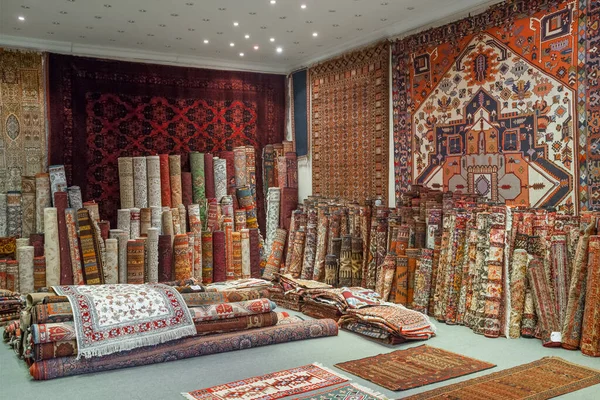 Variety of the gorgeous oriental carpets in traditional carpet store in Middle East. Pile of beautiful handmade carpets on the traditional Middle East market bazaar.