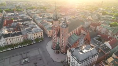 Pazar meydanındaki St. Marys Bazilika Kilisesi ya da Krakow, Polonya 'da gündoğumunda Rynek Glowny. Krakow 'un merkez meydanındaki hava manzarası Sabah yumuşak güneş ışığı
