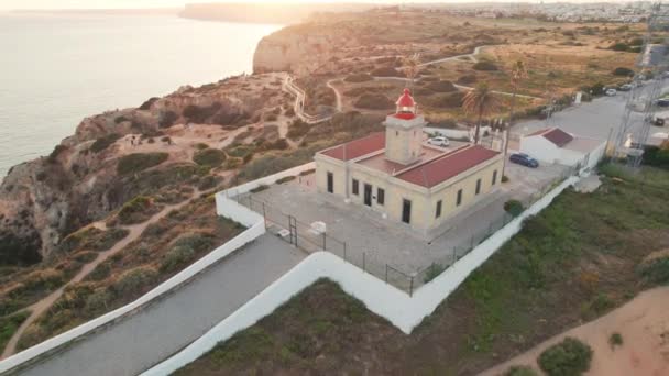 葡萄牙阿尔加维地区拉各斯镇日落时分 Ponta Piedade灯塔在悬崖上的空中景观 Farol Ponta Piedade Lagos的无人机镜头 — 图库视频影像