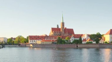 Slow panning across Ostrow Tumski Island on the Odra River in Wroclaw, Poland. Panoramic view on Wroclaw Old Town. Island and Cathedral of St John with bridge through river Odra.