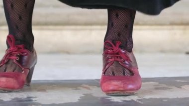 Flamenco dancers legs in red shoes close-up in slow motion, Andalusia, Spain. Traditional Spanish flamenco dance shoes, leather high heels. Woman dancing flamenco in black skirt and leather shoes.