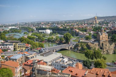 Güneşli bir günde Tiflis şehri manzarası, Georgia. Şehir merkezinin ve Tiflis 'teki Kura Nehri' nin üst manzarası. Yazın Gürcistan başkentinin hava manzarası