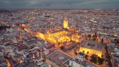 Geceleri Seville Katedrali, İspanya 'nın Endülüs bölgesindeki ünlü Gotik Katedrali' nin etrafında uçuyor. Seville Katedrali ve Giralda çan kulesinin hava manzarası. Endülüs 'ün insansız hava aracı görüntüleri
