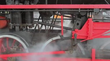 Buharlı tren lokomotifi tam hızda. Eski tarz trenin tekerleklerinin izini sürüyorum. Demir demiryolu lokomotif tekerlekleri buharla kaplıdır. Tarihi ulaşım teknolojisi kavramı