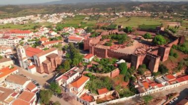 Portekiz 'in Algarve bölgesindeki ünlü ortaçağ şatosu ve katedrali olan Silves kasabasının hava manzarası. Silves Katedrali 'nin ve tarihi kalenin üzerinde uçuyor..