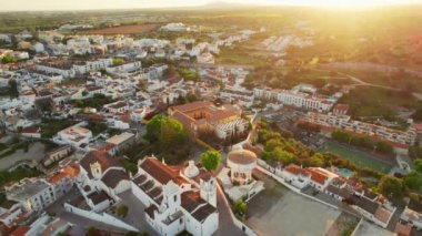Sabah güneşinde Portekiz 'in Tavira şehrinin merkezi. Güneş doğarken eski Tavira kasabasının havadan görünüşü, Algarve bölgesi, Portekiz. Merkez Meydanı, Ponte Romana Köprüsü ve tarihi binalar.