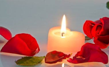 gül yaprakları yanan bir mum