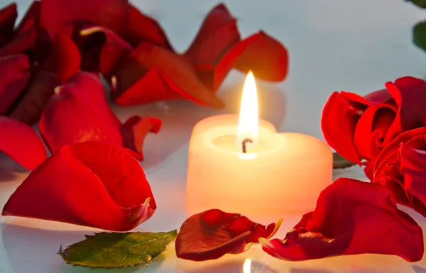 在玫瑰花瓣中燃烧的蜡烛 — 图库照片
