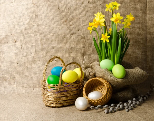 Colorful easter eggs in brown basket — Stock Photo, Image