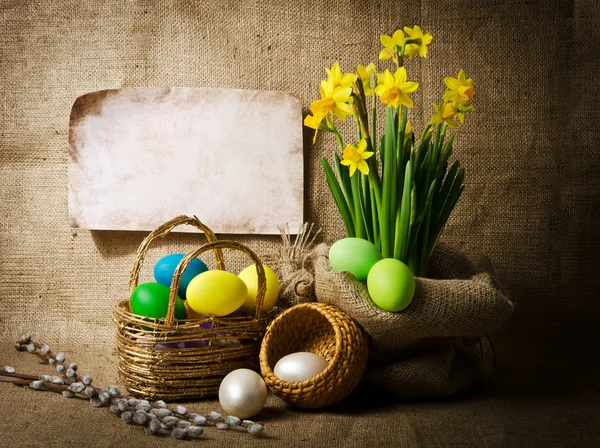 Colorful easter eggs in brown basket — Stock Photo, Image