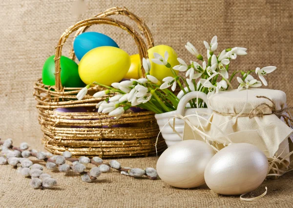 Colorful easter eggs in brown basket — Stock Photo, Image