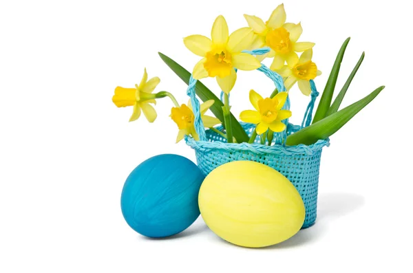 Easter eggs and daffodils in a basket — Stock Photo, Image