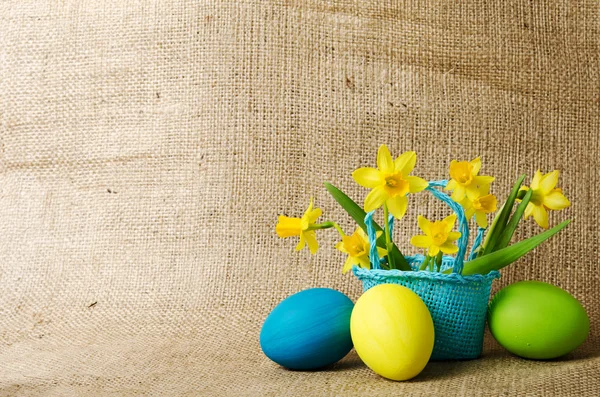 Huevos de Pascua y narcisos en una cesta —  Fotos de Stock