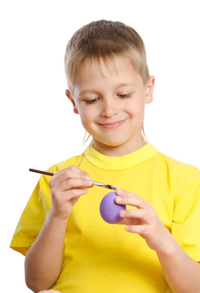 Little boy paints Easter eggs — Stock Photo, Image