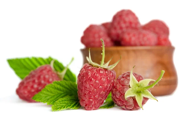 Framboises mûres sucrées dans une assiette en bois isolée sur fond blanc — Photo