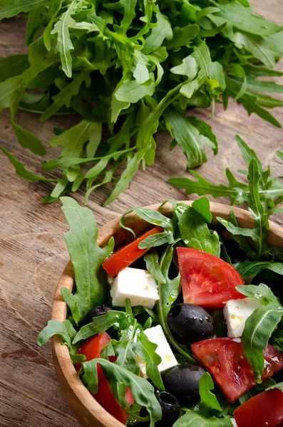 Salada grega em uma tigela de salada de madeira na mesa — Fotografia de Stock
