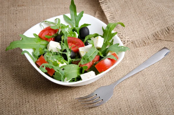 Grekisk sallad i vit salladsskål på säckväv — Stockfoto