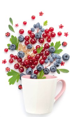 Meyve kokteyli. Çeşitli meyveler. Beyaz bir fincanda üzümler ve yaban mersinleri.