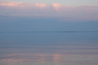 Akşam nehrinin üzerinde pembe bulutlar. Yaz batımı. Nehir manzarası.