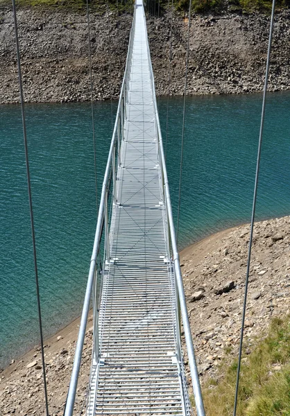 Alpine footbridge over lake Rechtenvrije Stockfoto's