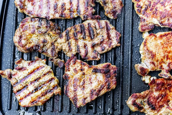 Teflon barbekü ızgarasında leziz domuz budu bifteği.