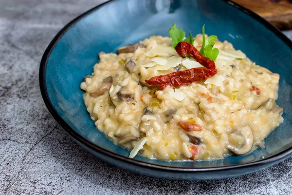 Mantarlı risotto ve mavi kasede kurutulmuş domates.