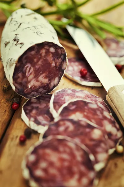 Salchichón de carne en rodajas tradicional sobre tabla de madera —  Fotos de Stock