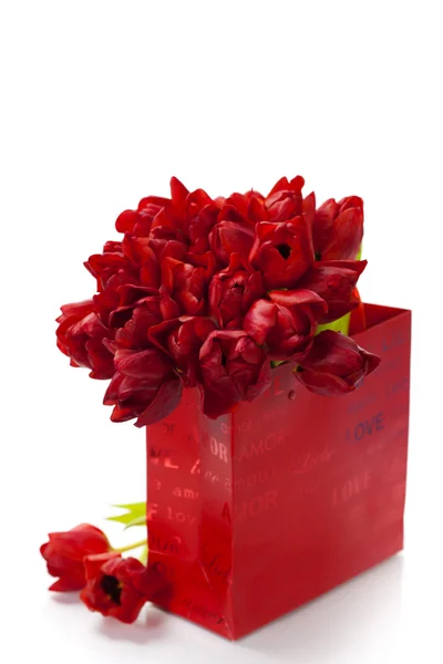 Valentine composition with shopping bag and red tulips — Stock Photo, Image