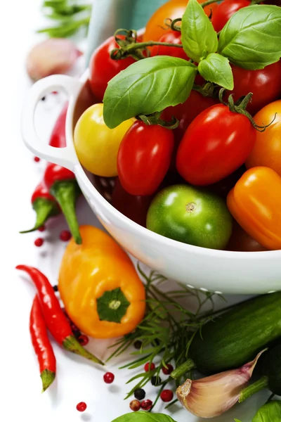 Geassorteerde tomaten en fruit in vergiet — Stockfoto