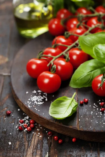 Pomodori con basilico su fondo tavolo in legno — Foto Stock