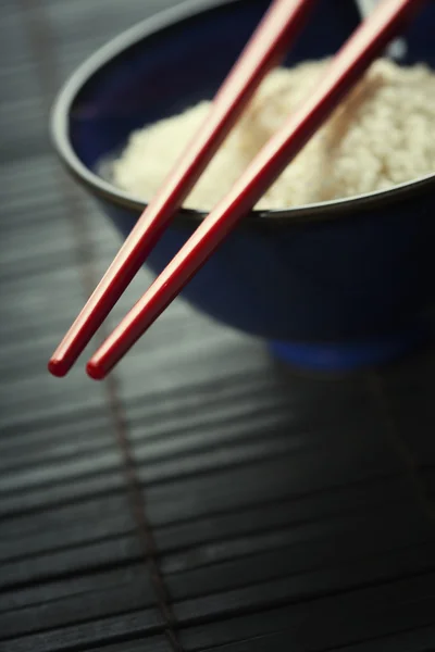 Чаша с рисом и палочками — стоковое фото
