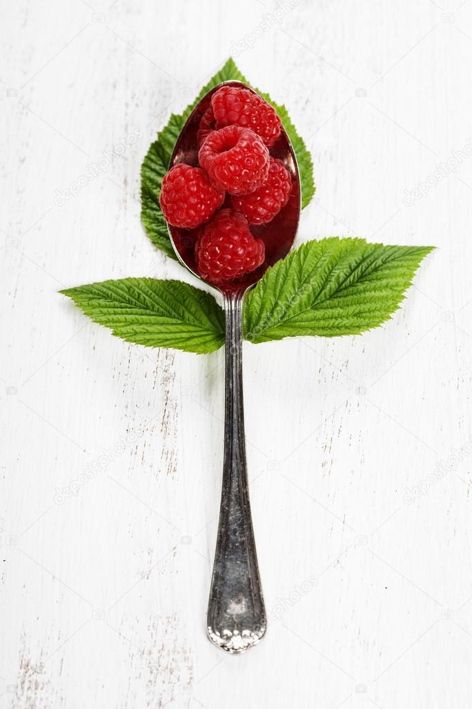 Fresh organic raspberry in a spoon.  Selective focus 