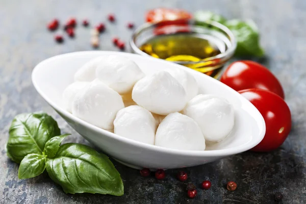 Mozzarella mit Tomaten und Basilikumblättern — Stockfoto