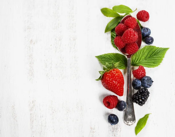 Beeren mit Löffel auf Holzgrund. Gesundheit, Ernährung, Gärtnern — Stockfoto